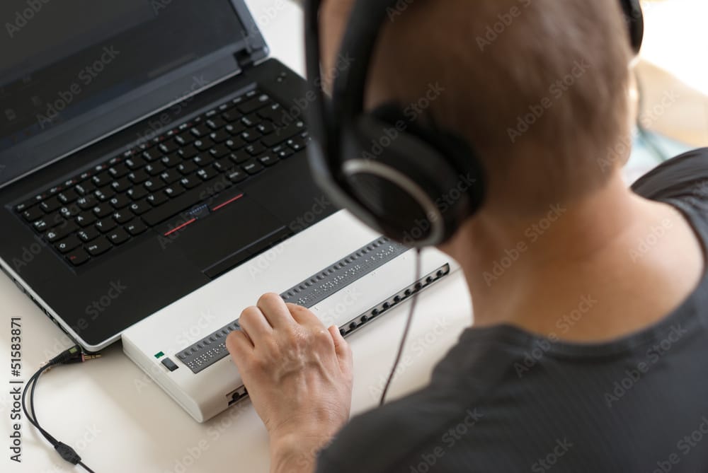 man with braille keyboard and headset