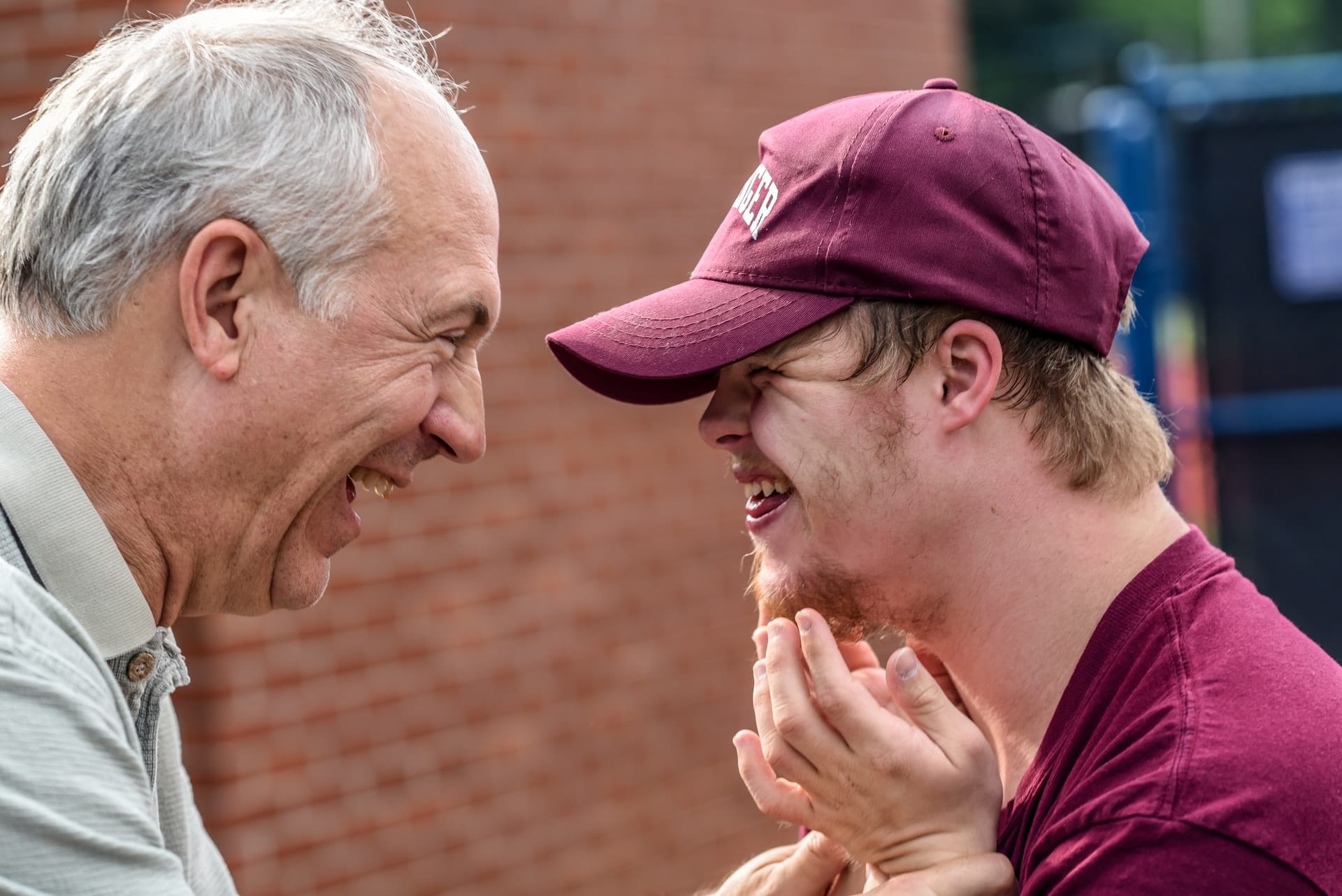 Older man laughing with younger man who has a disability