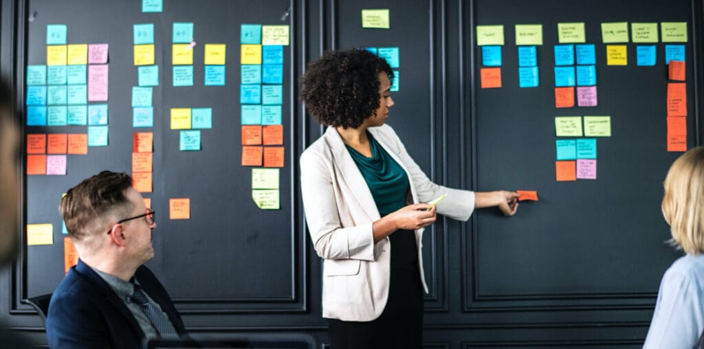 Woman making notes on post its and arranging them on a wall