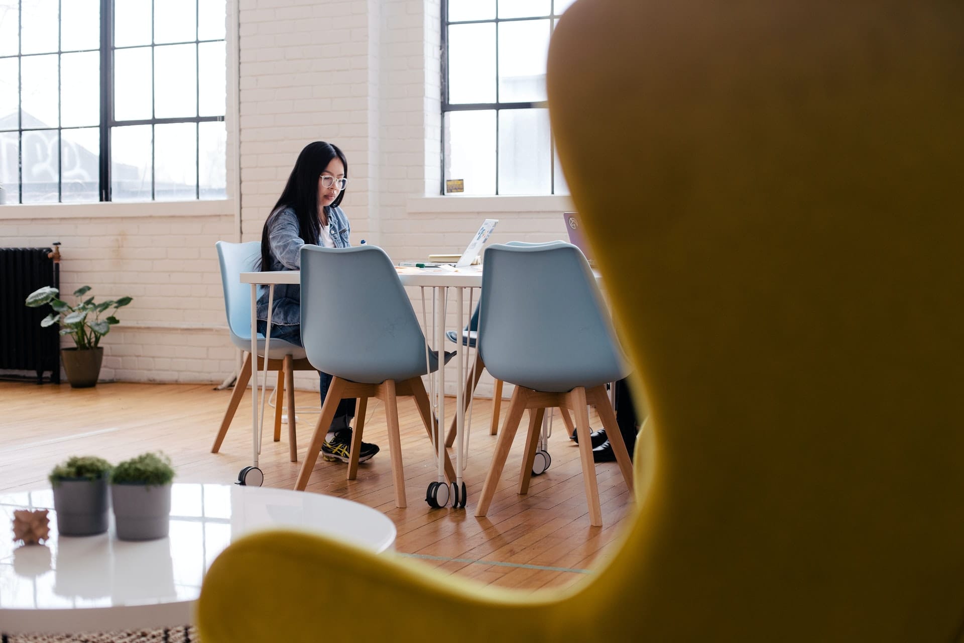 Woman sitting alone at workplace table in the distance