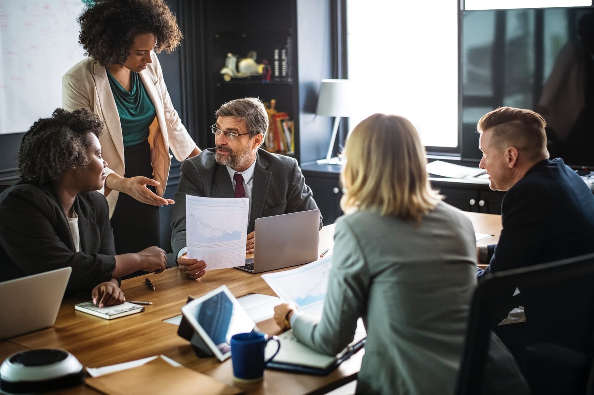 Professional woman showing man document during a team meeting