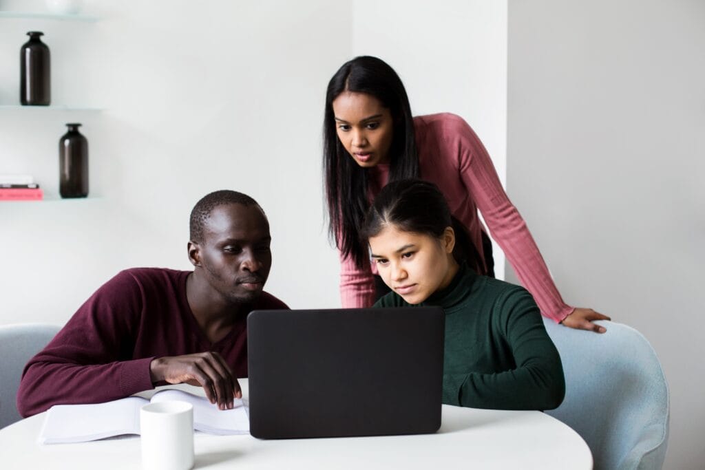 3 people looking at laptop