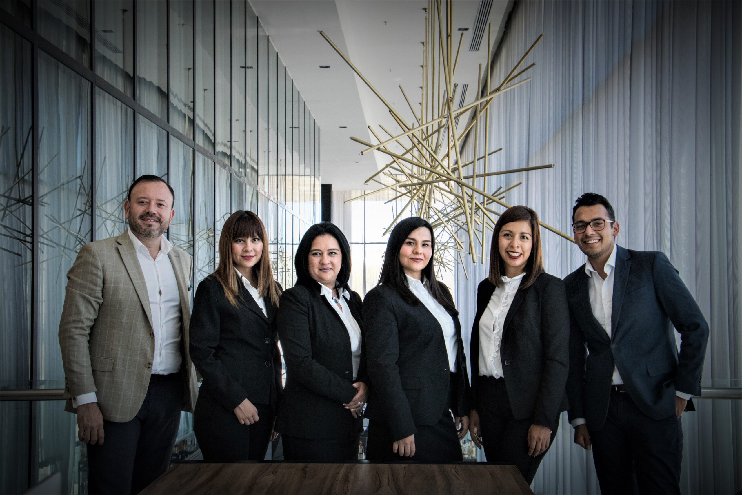 Group of professionals in suits posing for group photo at conference centre